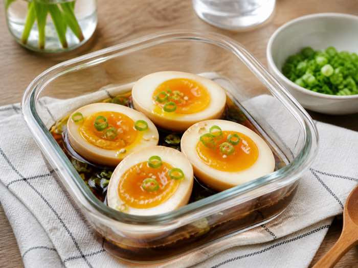 Korean soy-marinated soft-boiled eggs cut open over rice with scallion and sesame